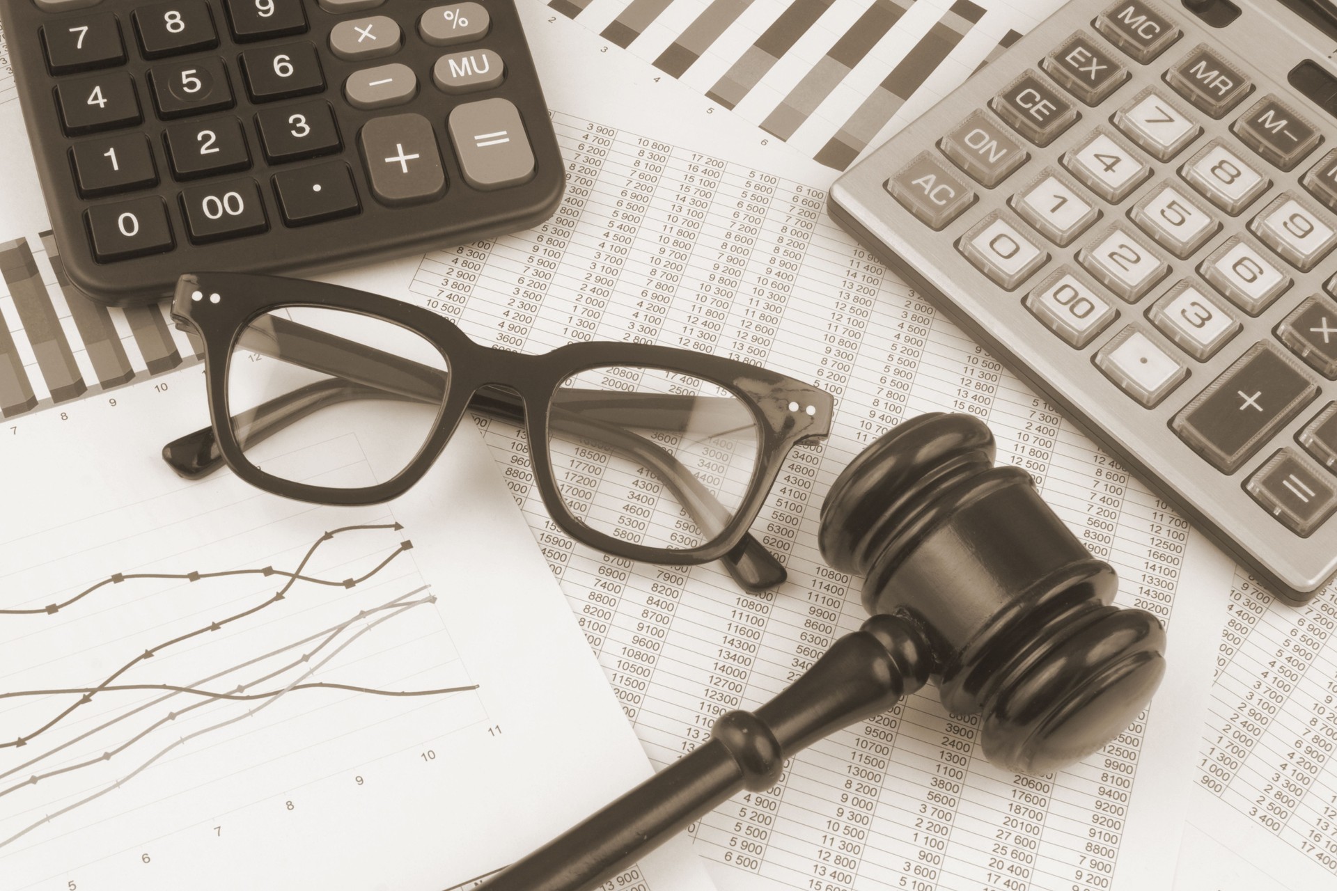 Judge gavel and calculators with glasses on financial documents
